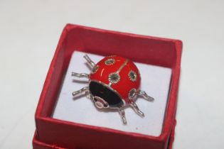 An enamelled Sterling silver brooch in the form of