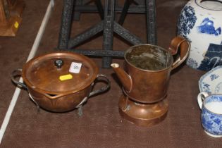 An Arts & Crafts copper pot lacking lid; and another Arts & Crafts copper and iron twin handled bowl