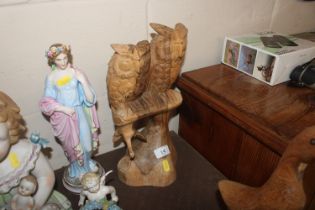 A carved wooden group in the form of two owls