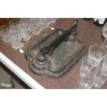 An ornate cast iron boot scraper