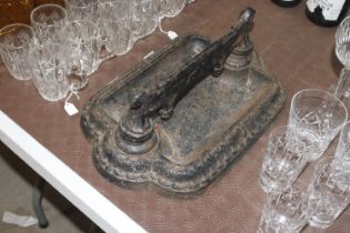 An ornate cast iron boot scraper