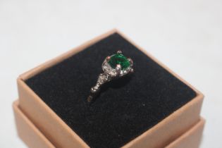 A white metal ring set with green coloured stone