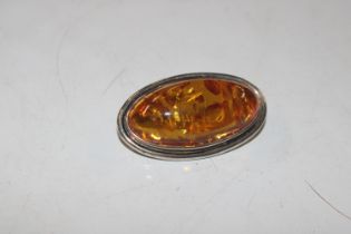 A large sterling silver and amber brooch