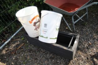 A plastic fermentation bucket with bottle lids con