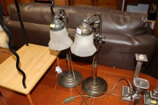 A pair of table lamps with glass shades