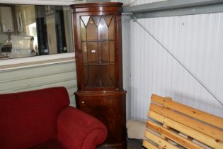 A reproduction mahogany corner cabinet