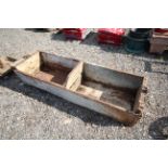 A vintage wooden two section feed trough