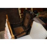 An antique carved oak cane seated and backed chair