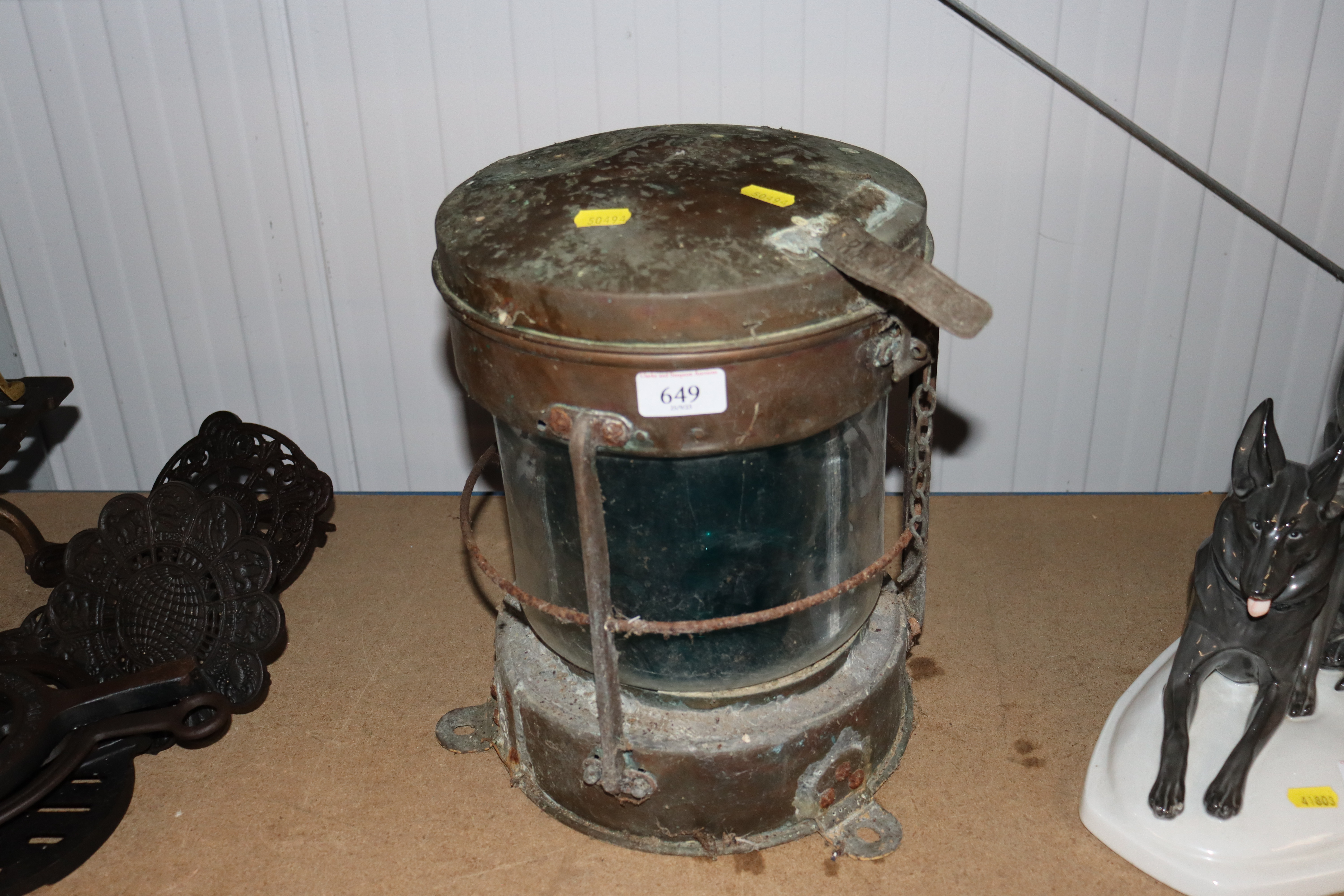 A copper ships lamp with label "Trawling"