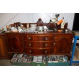 A carved mahogany bow fronted sideboard raised on