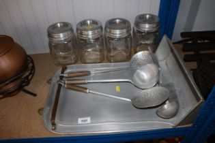 A set of four aluminium kitchen utensils and hangi