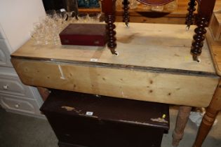 A stripped pine Pembroke table raised on turned su