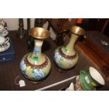 A pair of cloisonné decorated vases on hard wood s