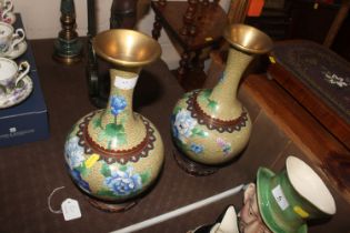 A pair of cloisonné decorated vases on hard wood s
