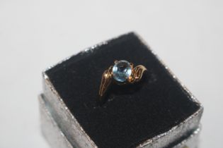 A yellow metal ring set with blue stone