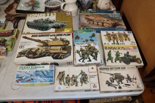 A collection of Tamiya and other boxed military mo