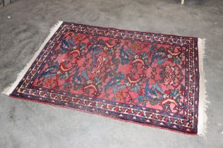 An approx. 5'2" x 3'7" red and blue patterned rug