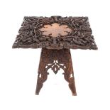 An Anglo Indian carved hardwood occasional table, with profuse foliate decoration, raised on a