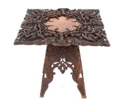 An Anglo Indian carved hardwood occasional table, with profuse foliate decoration, raised on a