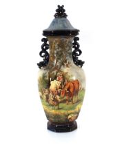 A large continental Majolica ware baluster vase and cover, decorated with cattle and herders, the