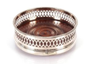 A late 20th Century silver and turned mahogany wine coaster, by Mappin & Webb, having pierced sides,