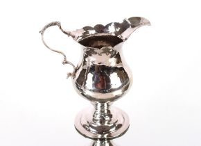 A George III silver baluster cream jug by John Lambe of baluster form having serrated border and