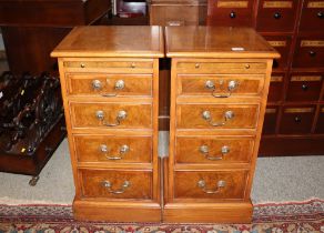A pair of walnut and herringbone banded bedside chests, fitted brushing slides and four graduated