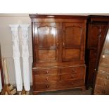 An antique oak press cupboard, the hanging compartment enclosed by a pair of panelled doors above