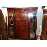 A Victorian mahogany combination wardrobe, fitted central shelves enclosed by arched panel doors,