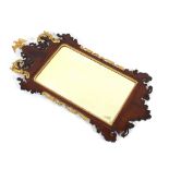 A mahogany and gilt wood Chippendale style wall mirror, with bevelled plate surmounted by and