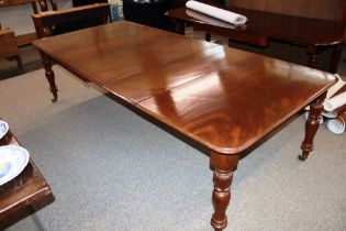 A Victorian mahogany extending dining table with three extra leaves, raised on leaf lappet turned