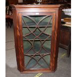 A Georgian mahogany hanging corner cupboard, enclosed by a single glazed tracery door, 77cm wide x