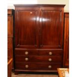 A Georgian mahogany linen press, converted to a hanging wardrobe, panelled door above two dummy