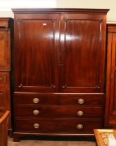 A Georgian mahogany linen press, converted to a hanging wardrobe, panelled door above two dummy