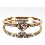 A diamond set yellow metal bangle, hinged with central fancy coloured diamond, approx. 1.5carat,