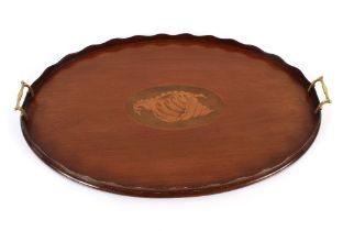 An Edwardian oval inlaid mahogany tea tray, having central conch shell motif, flanked by brass