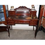 An Edwardian mahogany writing desk, the raised pierced back fitted central stationery compartment