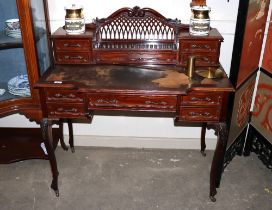 An Edwardian mahogany writing desk, the raised pierced back fitted central stationery compartment