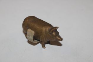 A vintage brass tape measure in the form of a pig