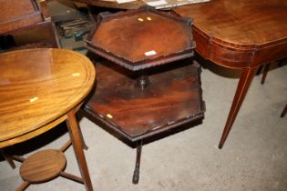 A mahogany two tier dumb waiter, raised on carved