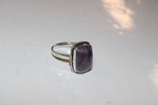 A silver and amethyst coloured ring