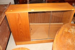 A bookcase fitted with sliding glass doors and sid