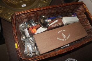 A basket containing a large quantity of silver pla