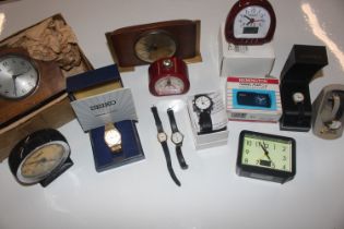 A box containing various wrist watches and alarm c