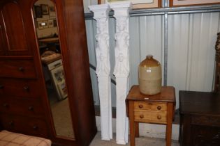 A pair of carved and white painted wooden pillars,