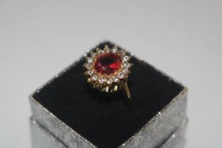 A yellow metal dress ring set with red and white s
