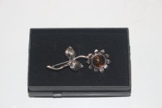 A silver and amber flower brooch