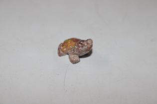 A miniature frog carved from a section of fire opa
