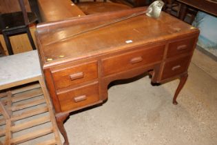 A dressing table fitted five drawers and raised on