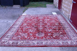 An approx. 13' x 9'11" red floral patterned rug AF